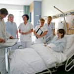 kórházban a beteg ágya körül orvos és nővérek