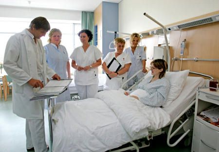 kórházban a beteg ágya körül orvos és nővérek